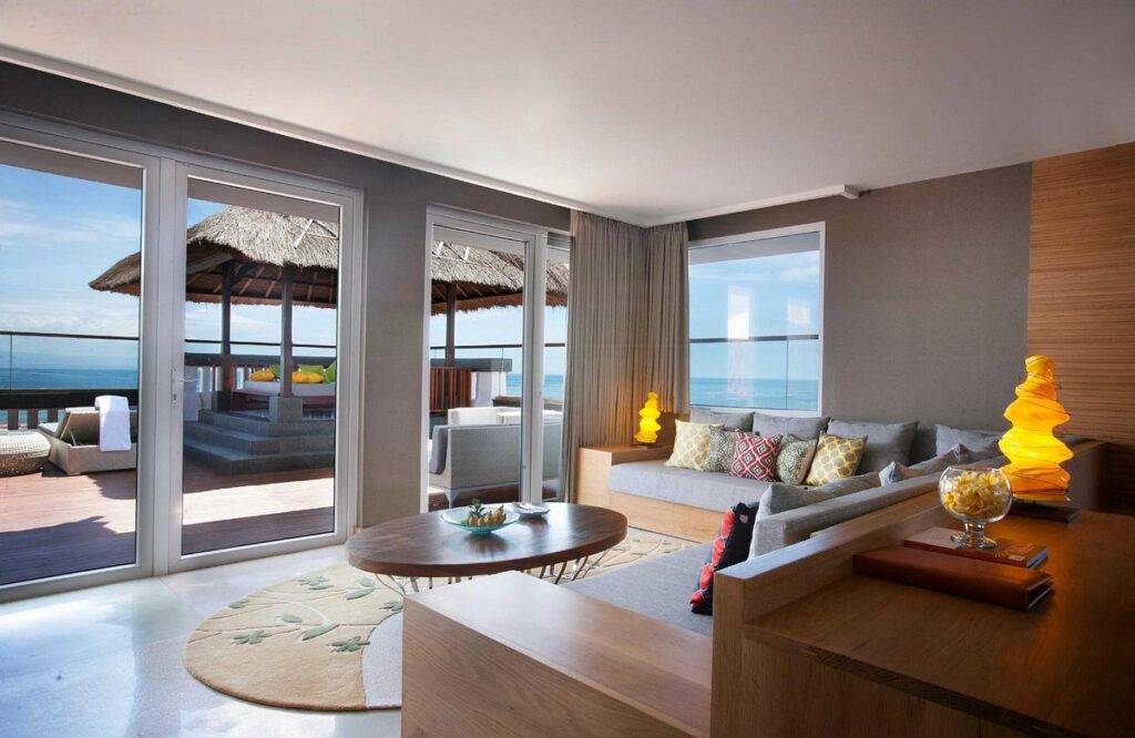resort room surrounded by windows looking out to ocean