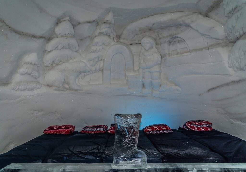 ice hotel room with sculpture and beds