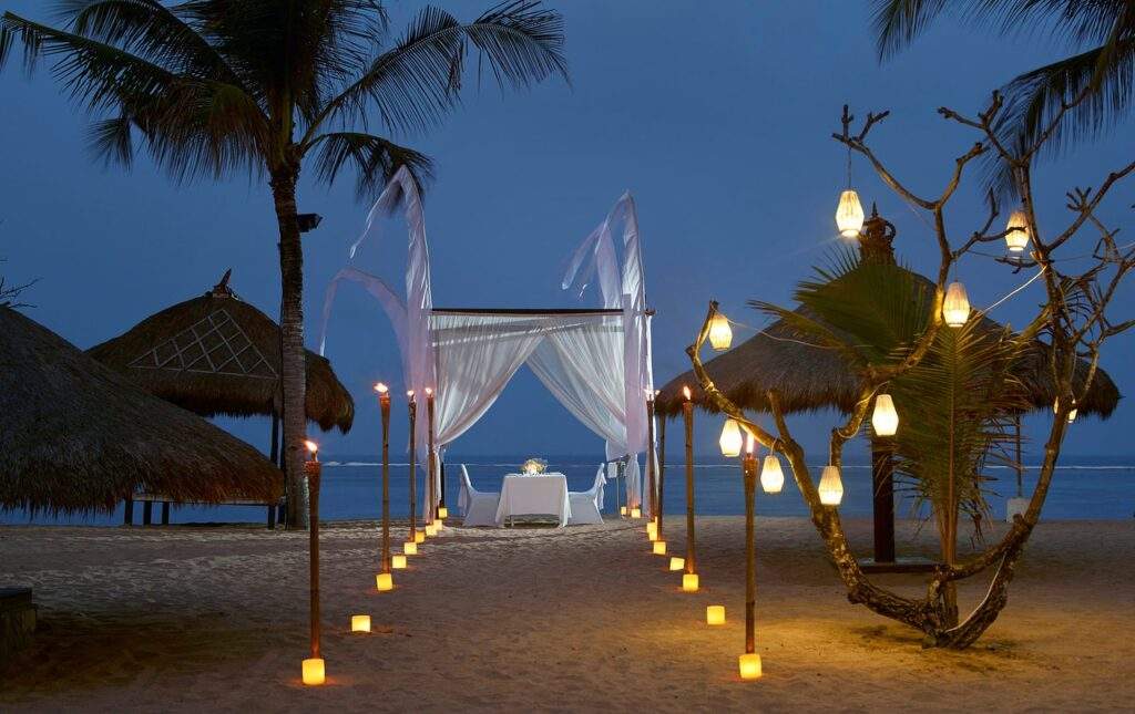 private table on beach at night with lighted path