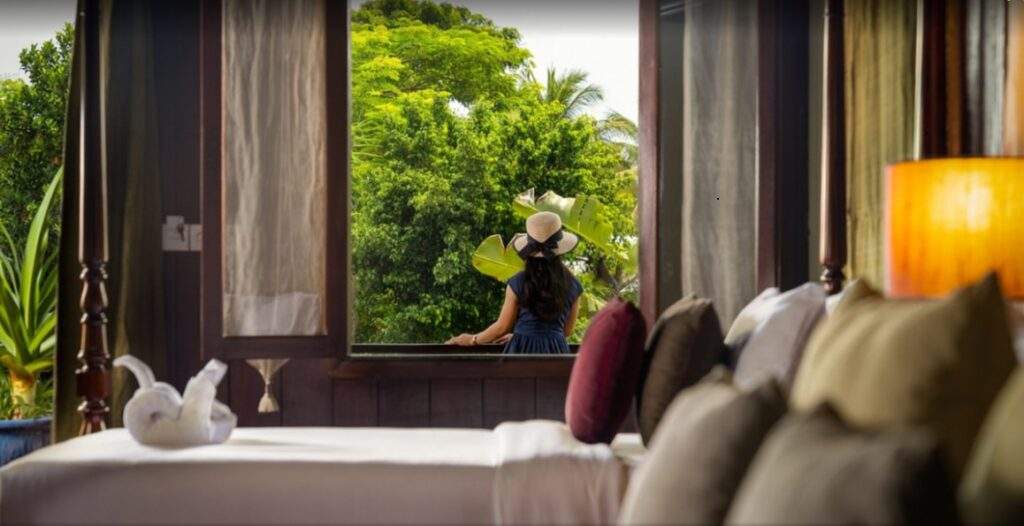 resort room with large open window with trees