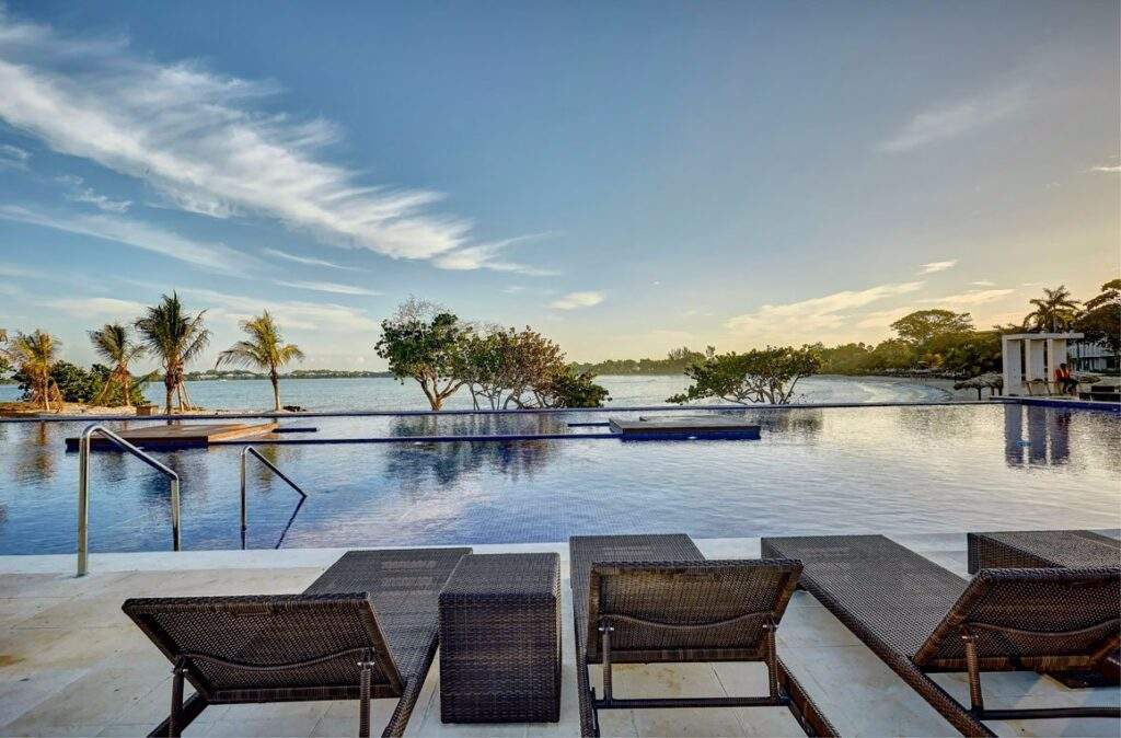 brown beach lounge chairs overlooking calm pool