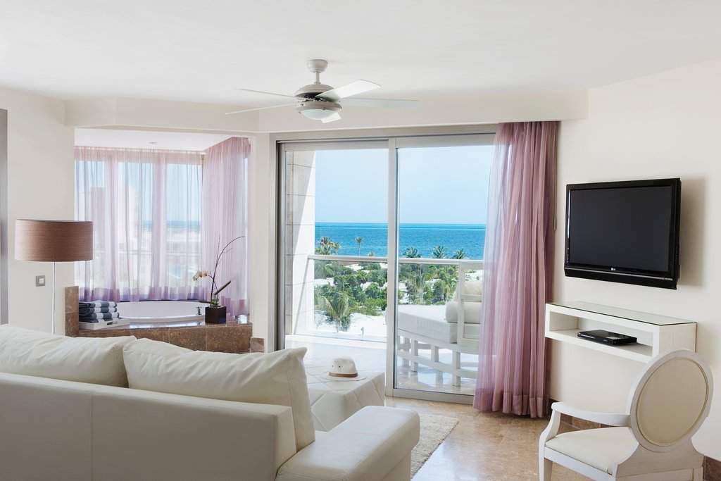 white couch facing sliding door looking at ocean