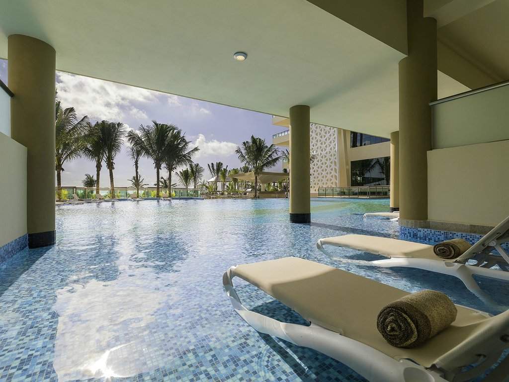spa chairs in pool looking at palm trees