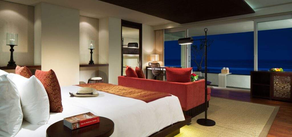 white bed behind orange couch