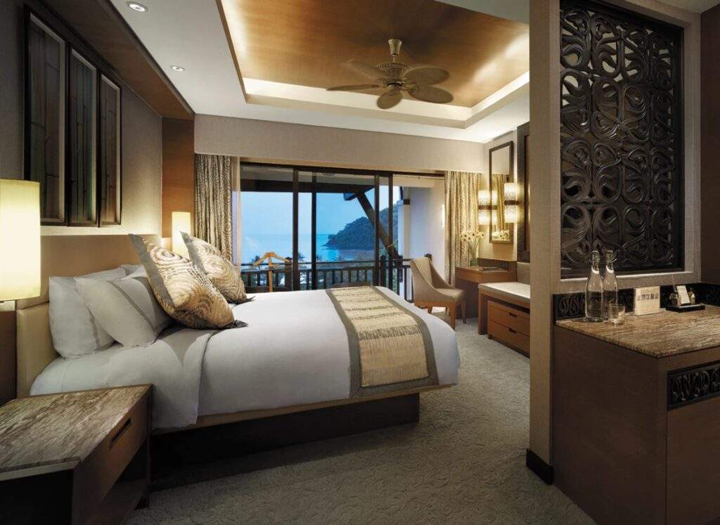 white bed tan pillows and ceiling fan