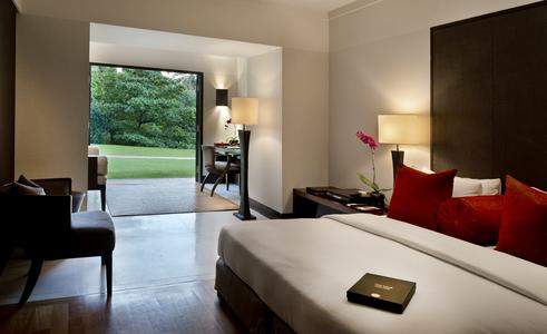 white bed with red pillows with open window