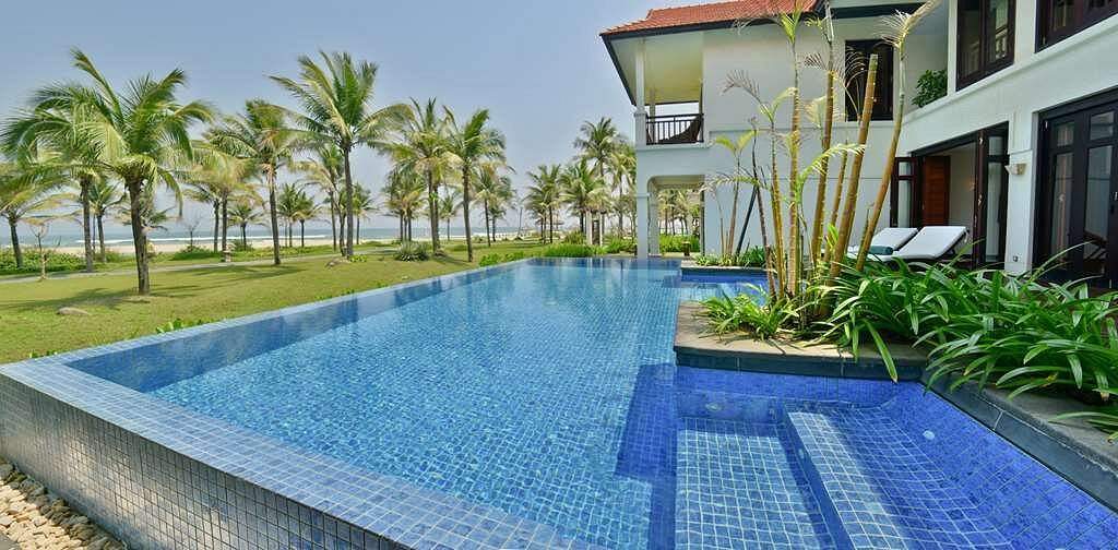 resort infinity pool behind palm trees