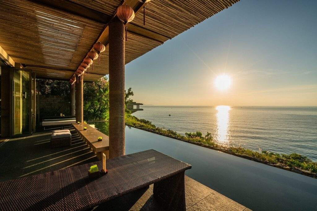 sun setting on water in front of resort infinity pool