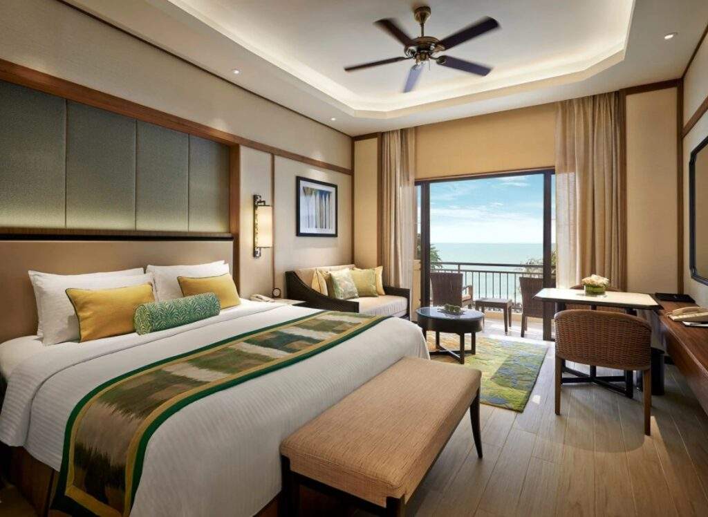 resort bed with large window looking at at sea