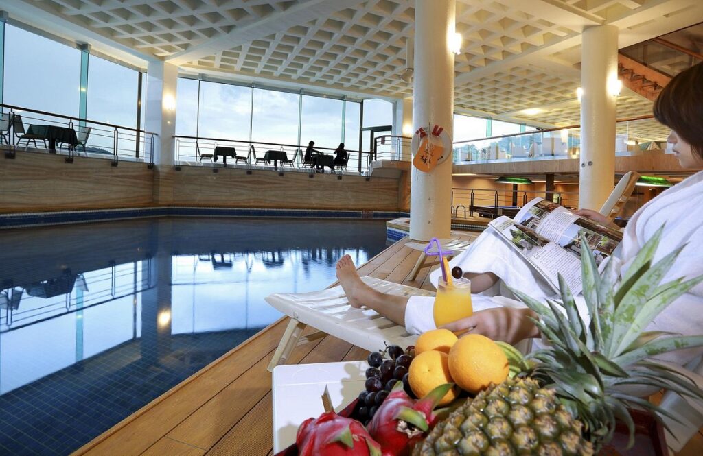 indoor pool with woman sitting next to fruit