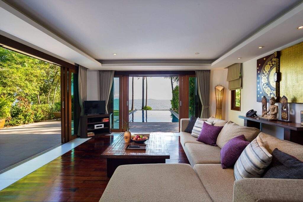 resort room with l-shaped couch with wide open door