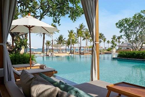 large square resort pool surrounded by cabanas