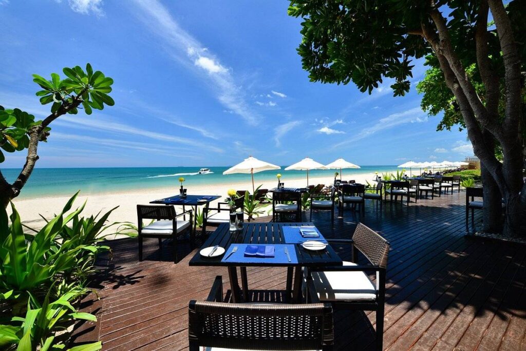 restaurant tables on wooden patio on the beach