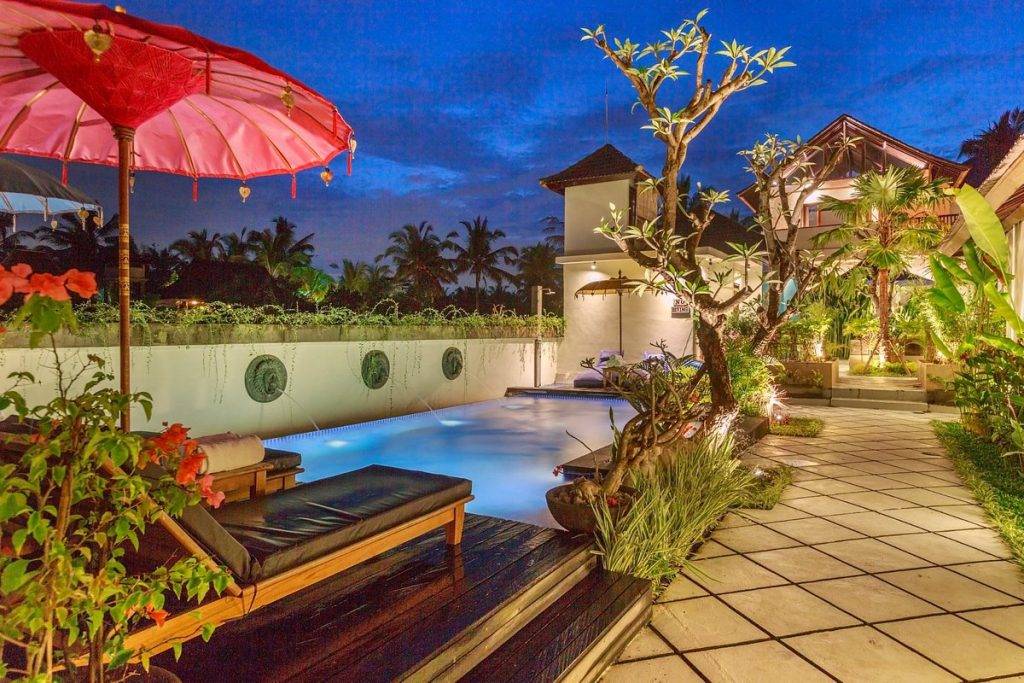 private pool with pink umbrella at night