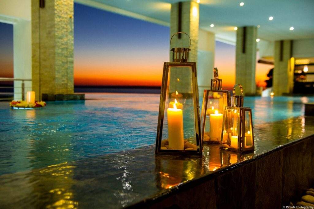 spa candles in front of infinity pool at sunset