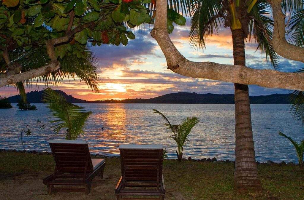 2 chairs on the beach at sunset