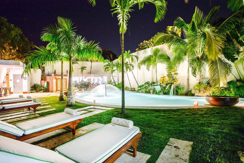 lounge chairs around lighted pool at night