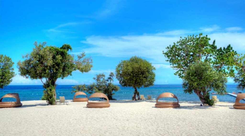 multiple cabanas on beach with trees