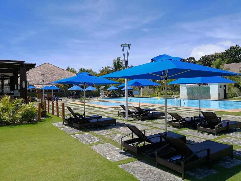 lounge chairs under blue umbrellas at pool