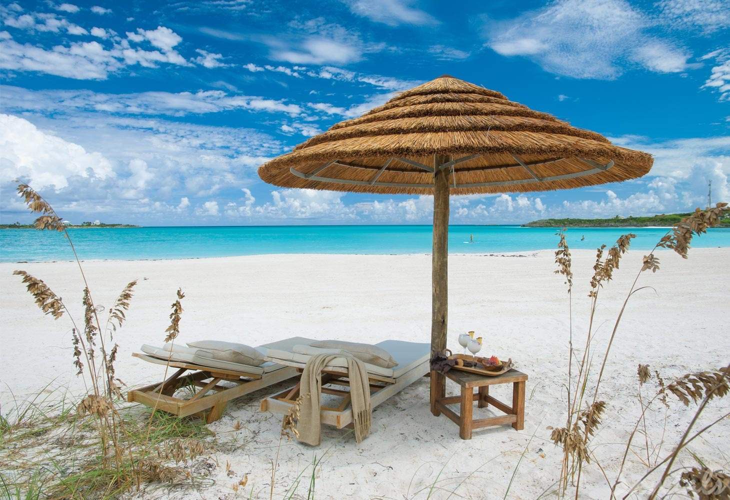 two lounge chairs on white beach