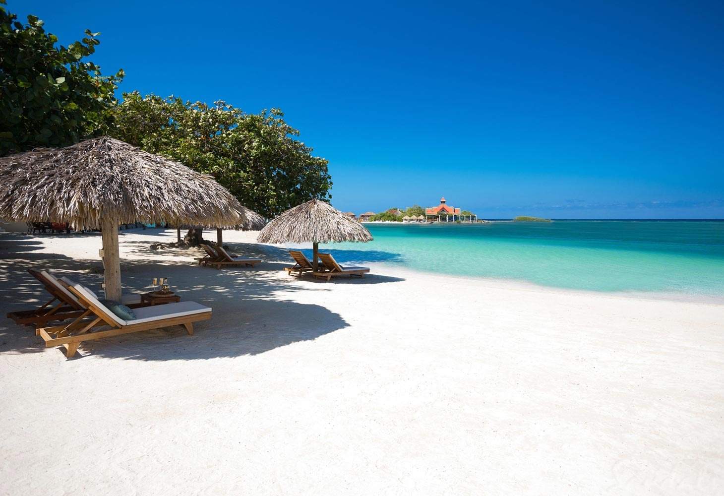 white sand beach with lounge chairs