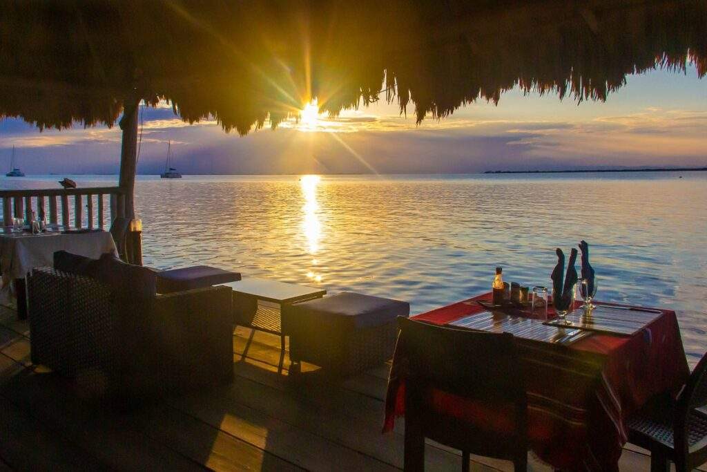 sun setting over ocean in front of beach