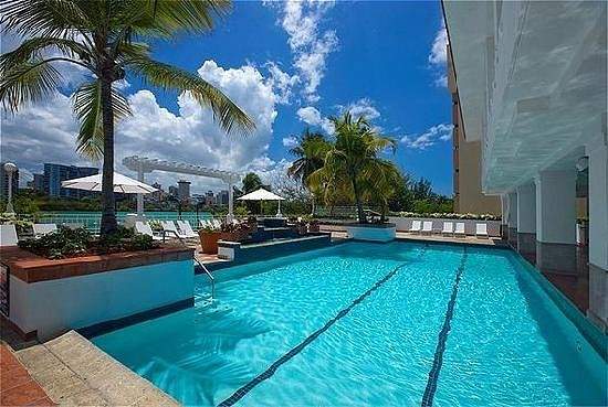 square resort swimming pool with palm trees