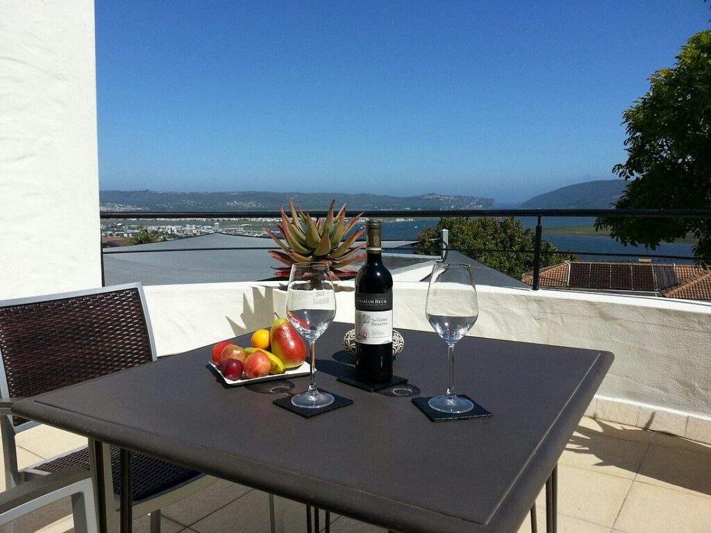 square table with wine glass overlooking water