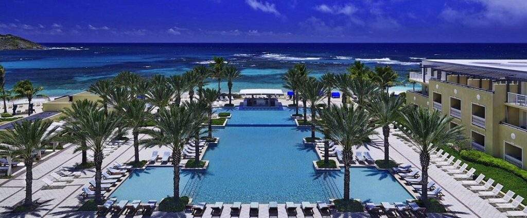 large resort pool and palm trees surrounded by ocean