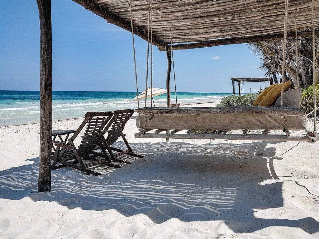 chairs under covering on white sand beach