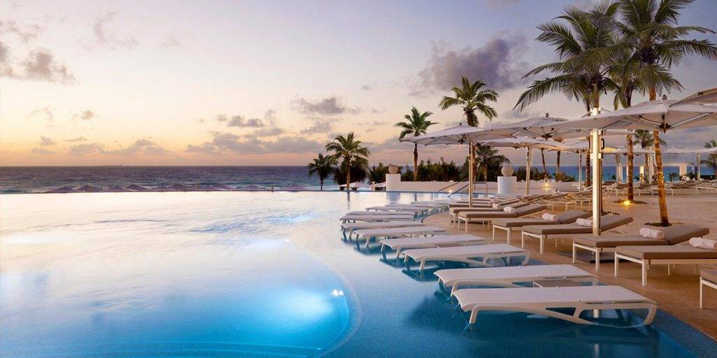 long white lounge chairs in resort pool