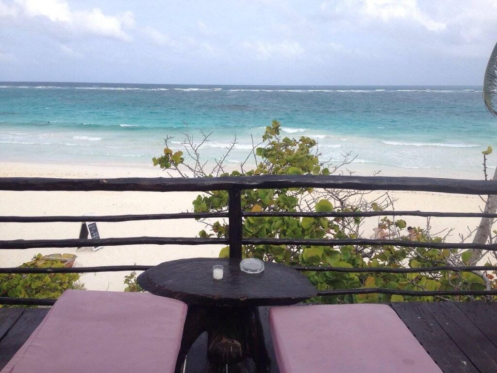 two resort lounge chairs on patio over beach