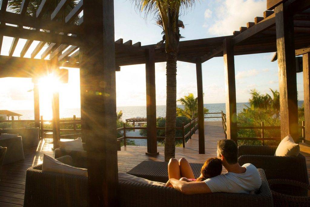 couple sitting on resort chairs at sunset