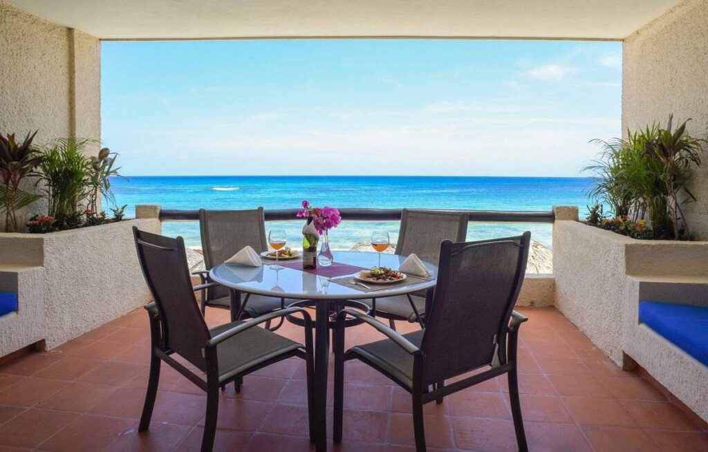 4 chairs on patio with ocean in background