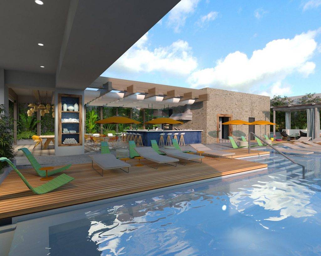 large resort pool surrounded by green lounge chairs