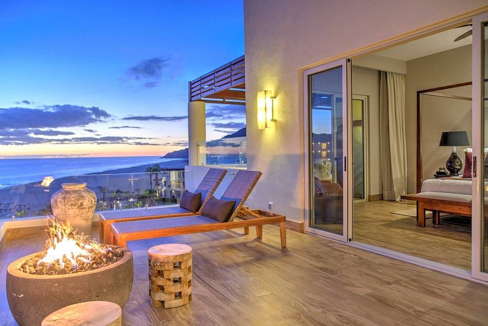 lounge chairs on private patio at beach at sunset