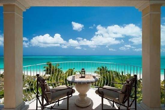 two chairs around small circular table looking down at ocean