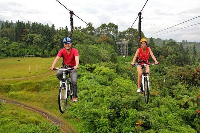 two people ziplining with bikes