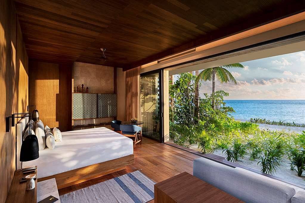 resort bed facing ocean thru wall to wall window