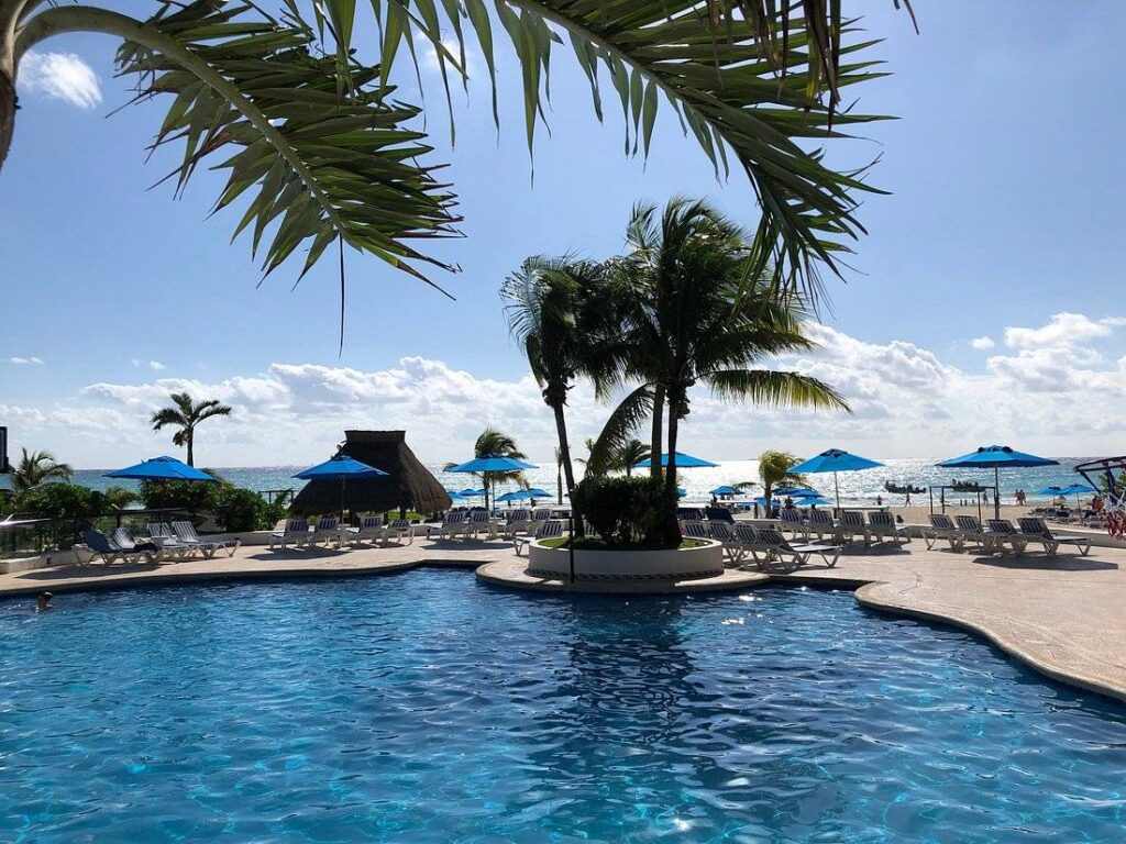 resort pool surrounded by blue umbrellas