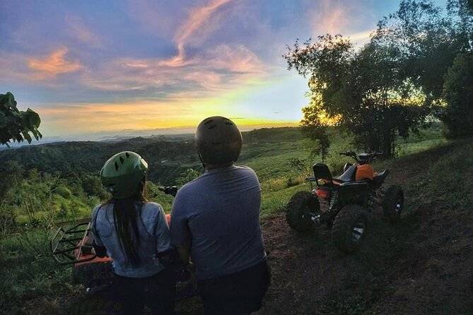 couple sitting on hill at sunset