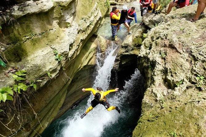 man jumping into water from cliff