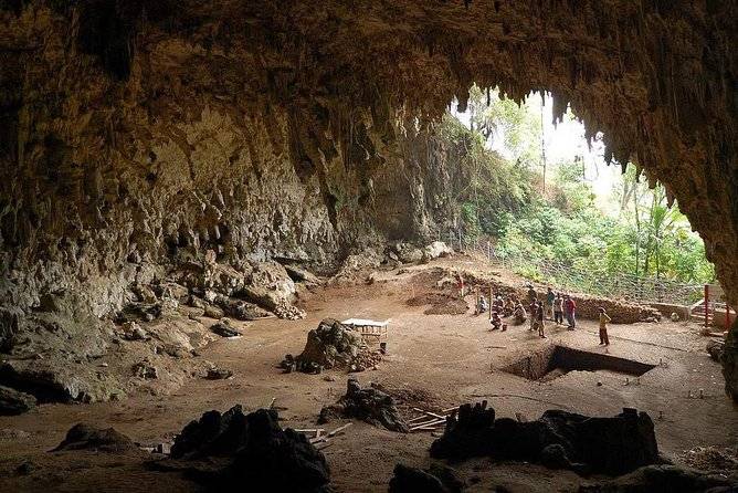 people walking to mouth of a cave