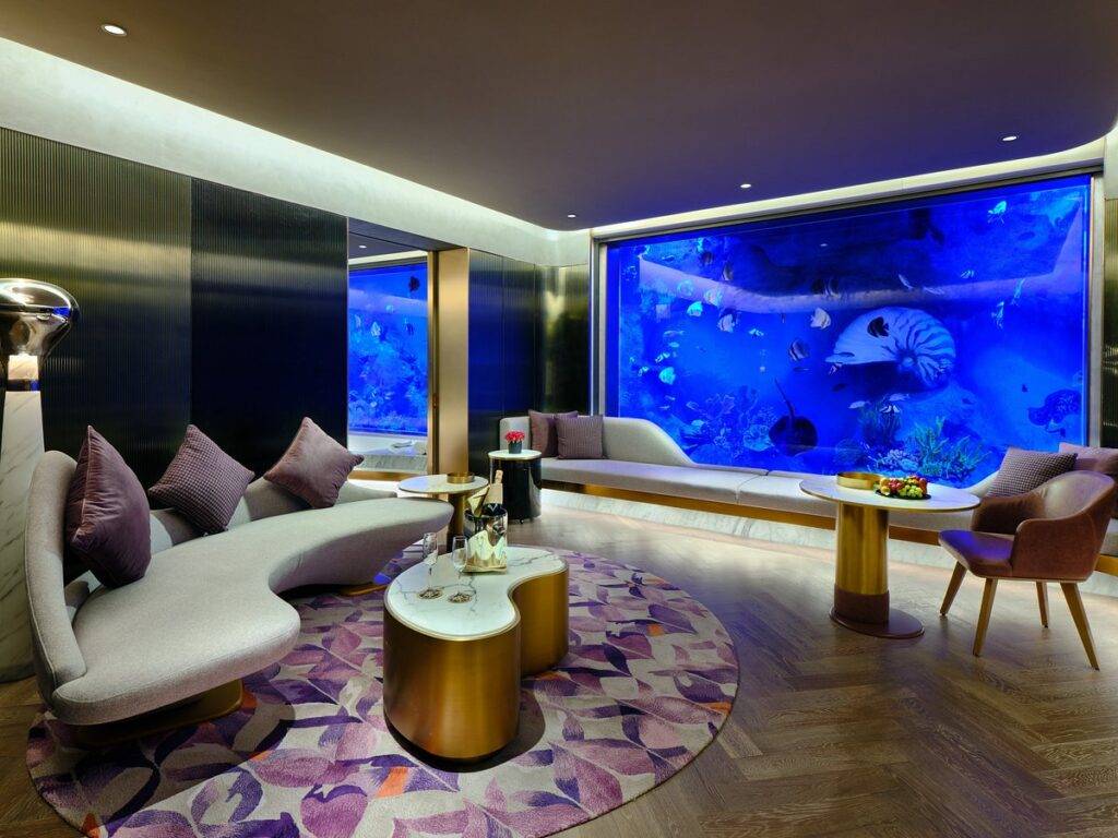 resort room with fish swimming outside window
