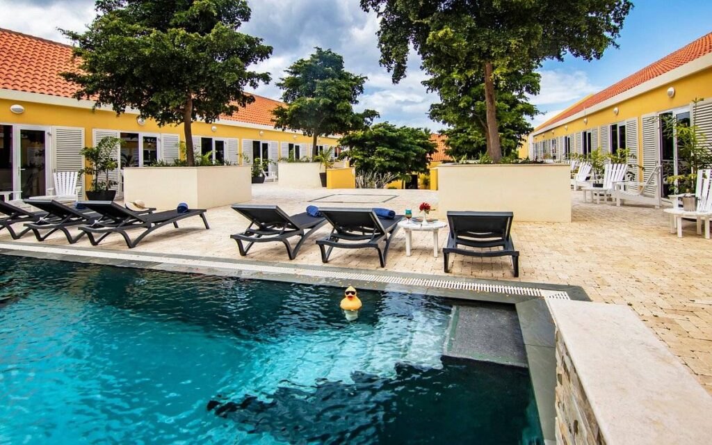 swimming pool with lounge chairs between two resort buildings