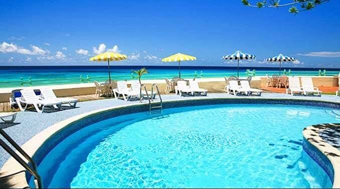 curved resort pool with lounge chairs and umbrellas