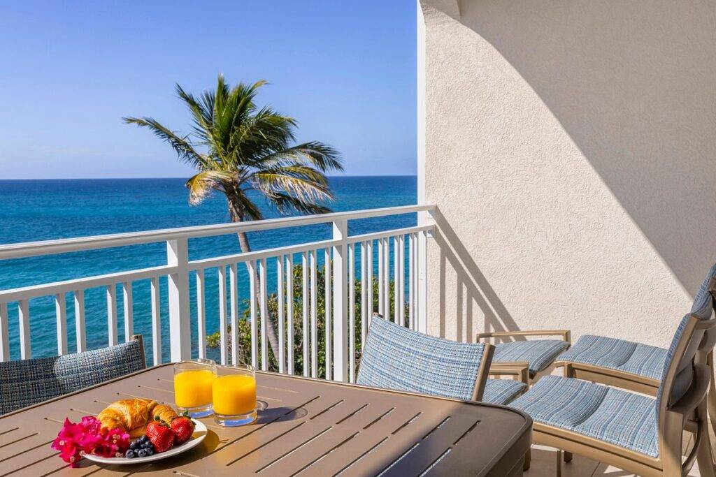 fruit and orange juice on table on resort patio at ocean
