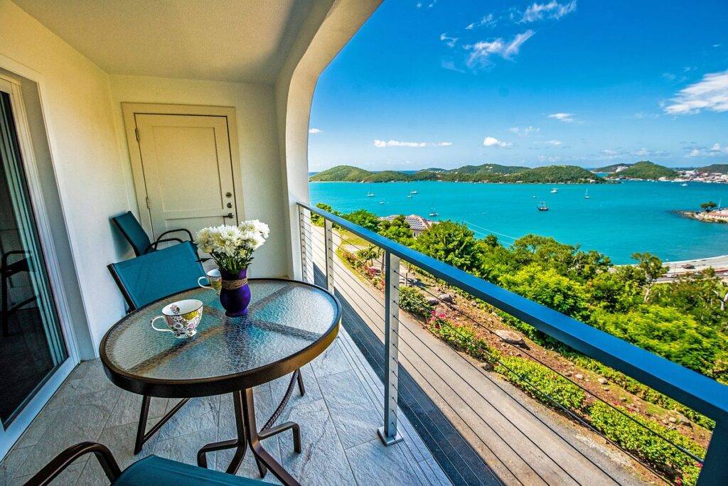 round glass table with chairs on balcony at beach