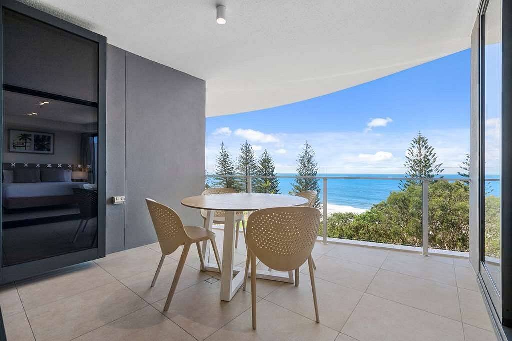 two chairs and table on patio at ocean
