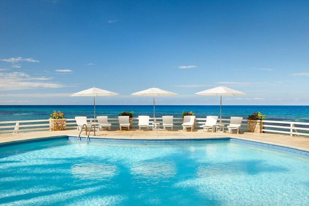 3 white umbrellas at resort pool